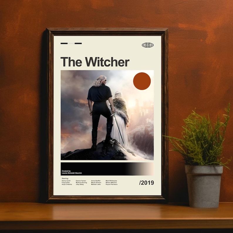 Pu&ograve; includere: Un poster incorniciato di "The Witcher" con un'immagine centrale di due figure su una cima rocciosa. Il poster ha un design minimalista con il titolo in grassetto, un cerchio marrone e l'anno 2019.