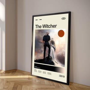 Pu&ograve; includere: Poster incorniciato di "The Witcher" con bordo nero. Il poster ha uno sfondo color crema con il titolo in nero, un cerchio rosso e un'immagine di due figure su una montagna. L'anno 2019 &egrave; in basso a destra.