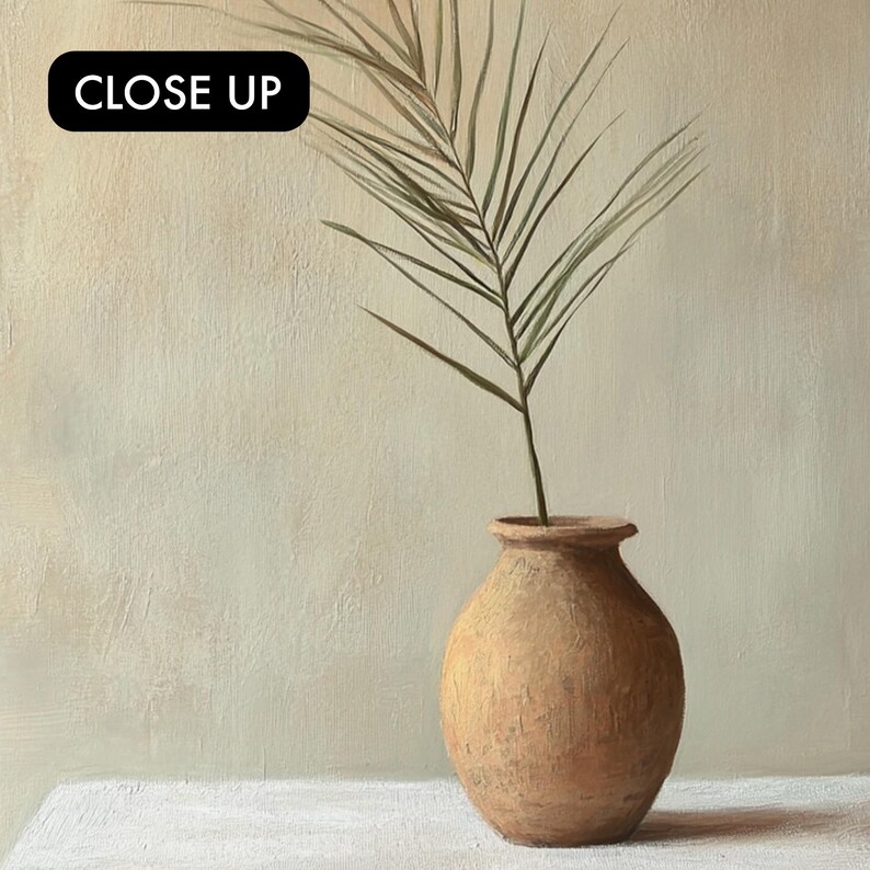May include: A single palm frond in a terracotta vase against a light beige background. The vase is round and has a textured surface.