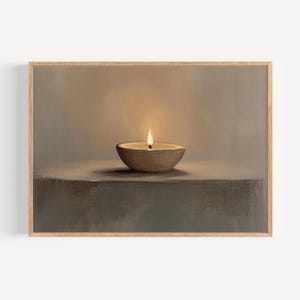Può includere: Dipinto incorniciato raffigurante una candela accesa in una piccola ciotola rotonda. La fiamma della candela brilla su uno sfondo neutro. L'opera d'arte utilizza una tavolozza di colori caldi e tenui, con un focus sulla luce e l'ombra.