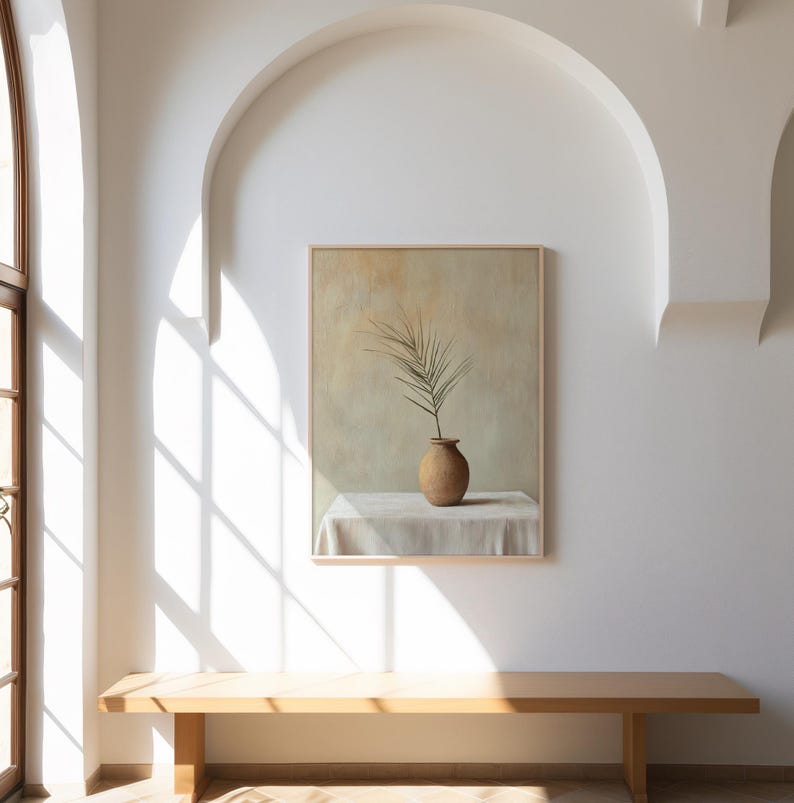 May include: A framed painting of a single palm frond in a terracotta vase on a white tablecloth. The painting is set against a light beige background.
