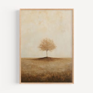 Könnte beinhalten: Ein gerahmter Kunstdruck mit einem einzelnen Baum mit goldbraunem Laub, vor einer gedämpften beige-braunen Landschaft. Das Kunstwerk hat eine minimalistische Ästhetik mit hellem Himmel und einer erdigen Farbpalette. Der Rahmen ist aus hellem Holz.