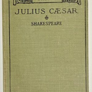 May include: A vintage book titled "Julius Caesar" by Shakespeare. The cover is a muted green with black text and decorative elements. The book is part of the "Standard English Classics" series.