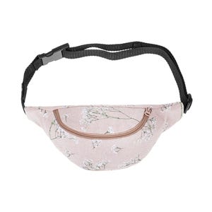 May include: A light pink fanny pack with a floral pattern of white flowers and green stems. The bag has a curved zipper closure and a black adjustable strap with a plastic buckle. The fanny pack is designed to be worn around the waist or across the body.
