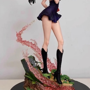 May include: A black and purple anime figurine of a woman wearing a short dress and black boots. The figurine is standing on a base with a red and white swirling effect.