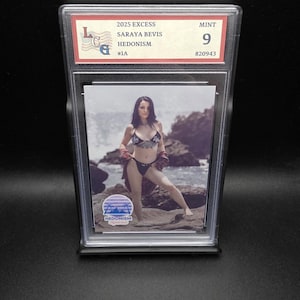 May include: A graded trading card featuring Saraya Bevis from the 2025 Excess set. The card is graded a 9, labelled "MINT." The card's image shows a woman in a bikini on a rocky beach. The card is encased in a protective holder.