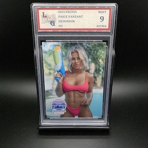 May include: A trading card in a protective case. The card shows a woman in a pink bikini with a blue and green water pistol. Text on the card reads "2025 Excess Paige Vanzant Hedonism #11" and "Mint 9".