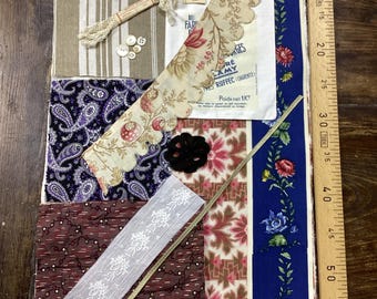 Könnte beinhalten: Eine Sammlung von Stoffmustern, Spitze, Knöpfen und Besätzen. Enthält Paisley-, Blumen- und Streifenmuster in verschiedenen Farben. Ein Holzlineal liegt an der rechten Seite der Stoffe. Der Text "PRES RUFFEC CHARENTE Poids net 1K" ist sichtbar.
