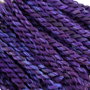 May include: A close-up of a bundle of purple and blue embroidery floss. The floss is twisted and has a variegated color pattern.