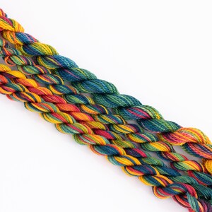 May include: Three skeins of embroidery floss in a rainbow of colors, including red, orange, yellow, green, blue, and purple.