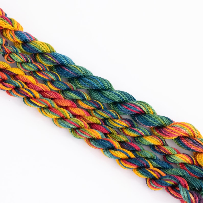 May include: Three skeins of embroidery floss in a rainbow of colors, including red, orange, yellow, green, blue, and purple.