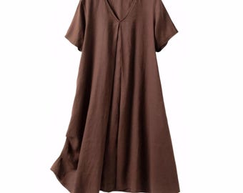 May include: A brown, short-sleeved dress with a V-neck. The dress has a loose, flowing silhouette and a pleated detail down the front. The fabric appears to be a lightweight material.