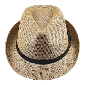 May include: A woven fedora hat in a natural beige color. The hat features a black band around the base of the crown and a classic fedora shape. The brim is slightly upturned, and the hat is made of a textured material.