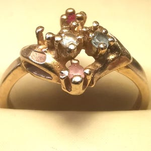 Puede incluir: Una taza de cerámica blanca con un asa negra y el texto "But First, Coffee" en negro, con una fuente de estilo manuscrito. La taza está sobre una superficie blanca.