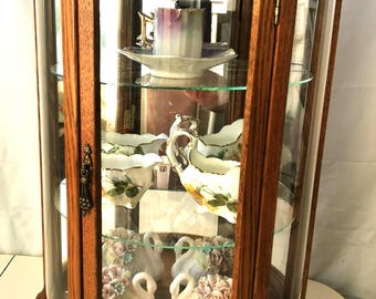Vitrina de madera vintage con puerta de cristal curvado y 5 figuritas vintage incluidas.