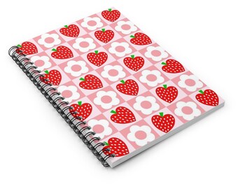 May include: A pink and white spiral notebook with a repeating pattern of red strawberries and white flowers.