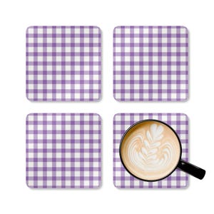 May include: Set of four purple and white gingham patterned coasters with a cup of coffee on one of the coasters.