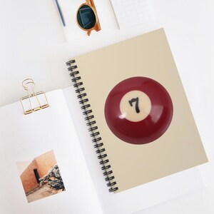 May include: A red billiard ball with a white number 7 on it.