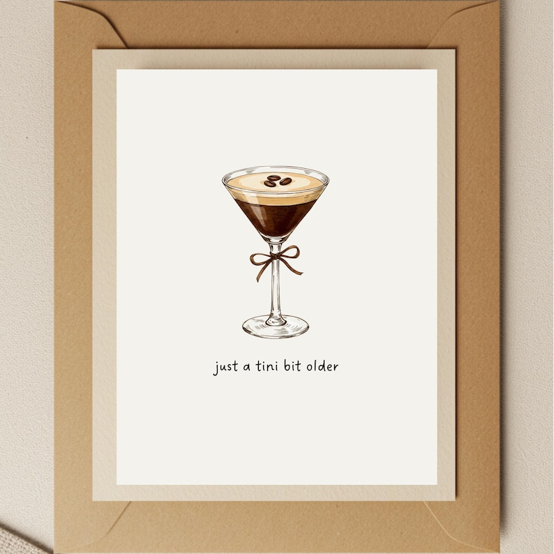 K&ouml;nnte beinhalten: Eine wei&szlig;e Karte mit einer handgezeichneten Illustration eines Kaffeemartinis mit Kaffeebohnen darauf. Der Text "just a tini bit older" steht unter dem Martini.