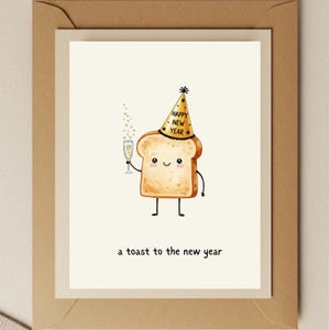 May include: Greeting card featuring a cartoon slice of toast wearing a party hat that says "Happy New Year." The toast holds a champagne flute. The text "a toast to the new year" is below the toast.