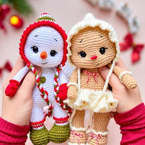 Könnte beinhalten: Zwei handgefertigte Häkelpuppen. Eine ist ein weißer Schneemann mit roter Kapuze, orangefarbener Nase und grünen Stiefeln. Die andere ist eine hellbraune Lebkuchenpuppe mit weißer Haube, weißem Rüschenrock und Schuhen mit rot-weißen Schnürsenkeln.