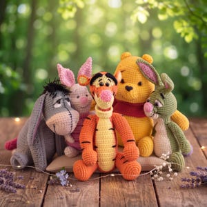 May include: A collection of five handmade crochet stuffed animals featuring a grey donkey, a pink piglet, an orange and black striped tiger, a yellow bear wearing a red shirt, and a green rabbit, all arranged together in a group.