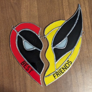 May include: Two stained glass hearts, one red and one yellow, with black outlines and white eyes. The hearts are broken apart and the words "BEST" and "FRIENDS" are written on them.