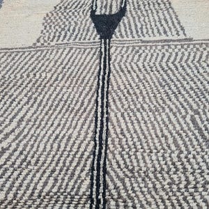 May include: A white and black patterned rug with a black stripe down the center. The rug has a textured, woven look.