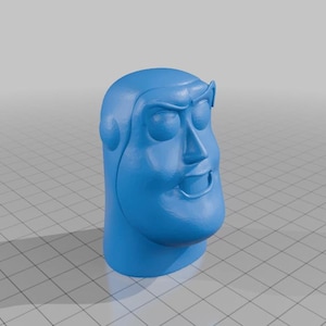 Puede incluir: Una figurita de plástico azul de la cabeza de un personaje con una expresión de ojos cerrados y una boca ligeramente abierta.