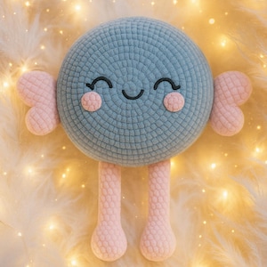 May include: A handmade, blue crocheted plush toy with a smiling face, pink cheeks, and pink appendages. The toy has a round head, two small arms, and two long legs. The background is a soft, fluffy, cream-colored surface with small, sparkling lights.