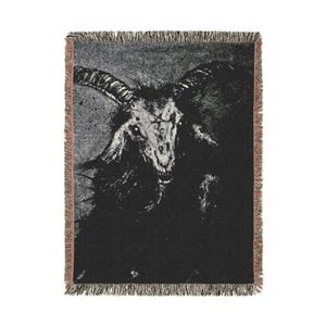 May include: Black and white woven tapestry featuring a detailed image of a goat with horns and a menacing expression.