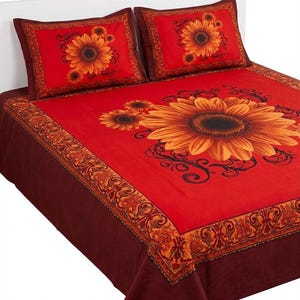 May include: Red and brown floral bed set featuring large sunflowers. The set includes a bedspread and two pillowcases. The bedspread has a large sunflower design in the center, with smaller sunflowers and decorative borders.