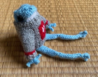 Sky blue geeky knitted frog wearing a jumper with a Pacman's red ghost pattern - vegan wool