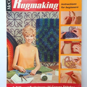 May include: Vintage McCall's "Step-by-Step Rugmaking" book cover. The cover features a woman in an orange dress, surrounded by rug samples in blue, green, and orange. The book includes instructions for beginners, with 8 different techniques and 14 canvas stitches.