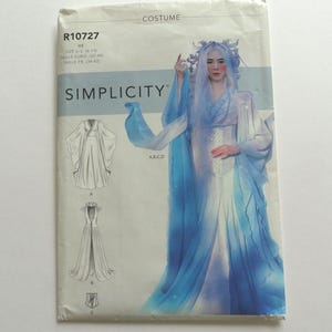 May include: A Simplicity sewing pattern envelope for a costume, model R10727, size U.S. 6-14. The package features a photograph of a person wearing a flowing, floor-length gown with blue and white ombre fabric, long sleeves, and a headpiece.
