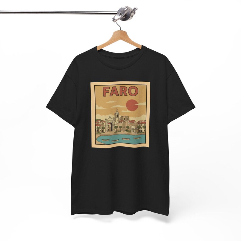 May include: Black t-shirt featuring a vintage-style graphic of Faro, Portugal. The design includes the word "FARO" above a red sun, with a coastal town scene below. The image is printed on a black tee.