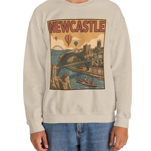 Detailed view of a vintage Newcastle city illustration on a sweatshirt showing a historic boat on the river and castle silhouette.