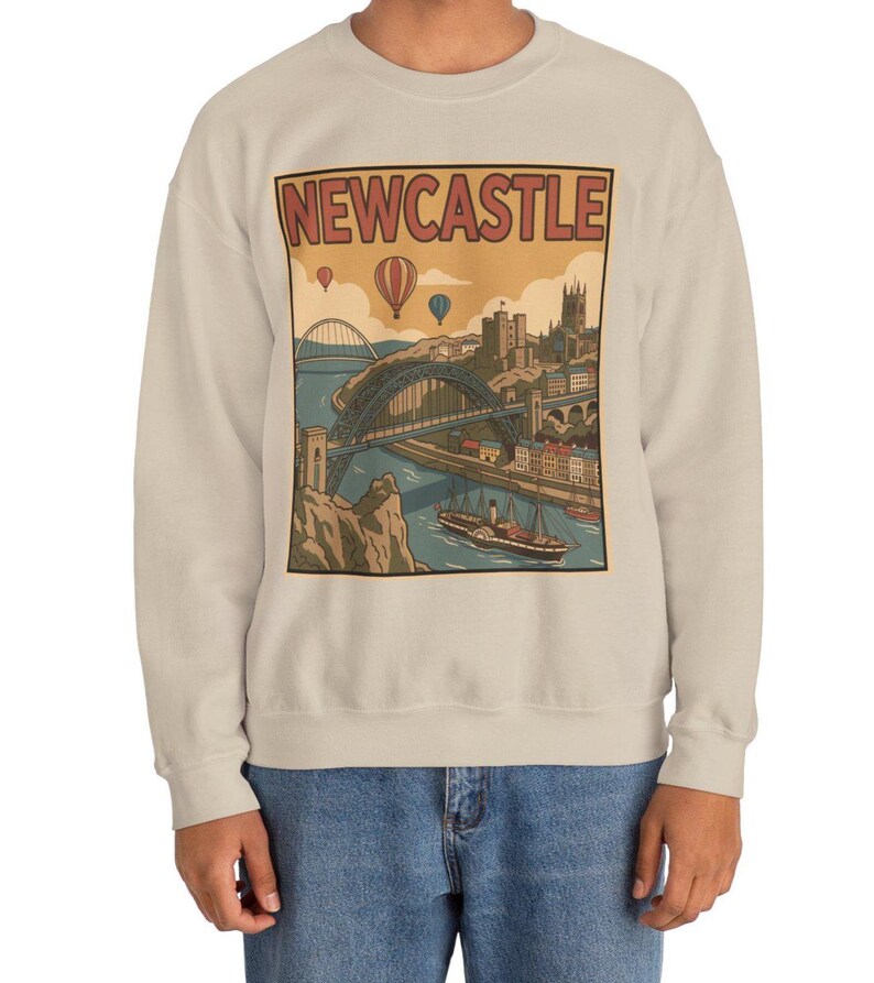 Detailed view of a vintage Newcastle city illustration on a sweatshirt showing a historic boat on the river and castle silhouette.