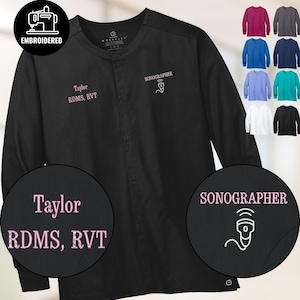Könnte beinhalten: Schwarze Langarm-Arztkitteljacke mit dem Namen "Taylor RDMS, RVT" in Rosa gestickt. Das Wort "SONOGRAPHER" und ein Sonogramm-Bild sind ebenfalls in Rosa gestickt. Zusätzliche Farboptionen werden angezeigt.