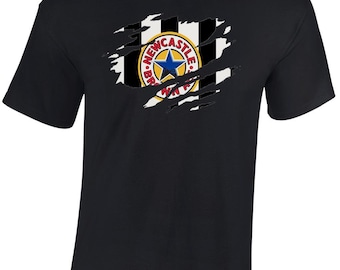Puede incluir: Camiseta negra con un gráfico desgastado del escudo del Newcastle United Football Club. El escudo es un círculo blanco y negro con una estrella azul y las palabras "Newcastle United" alrededor.