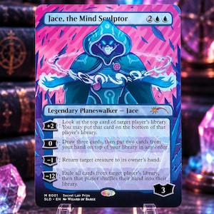 Puede incluir: Una carta coleccionable Jace, the Mind Sculptor con una figura estilizada con capucha azul y ojos brillantes, rodeada de energía. La carta muestra texto con habilidades, un coste de maná de 2UU y un valor de lealtad de 3 sobre fondo rosa.