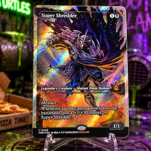 May include: A holographic trading card featuring the character Super Shredder in a dynamic pose. The card displays the text Super Shredder, Legendary Creature - Mutant Ninja Human, Menace, and game rules. It has a 1/1 power and toughness rating.