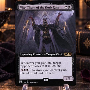 Puede incluir: Una carta coleccionable de Magic: The Gathering titulada Vito, Thorn of the Dusk Rose, con la ilustración de un clérigo vampiro. El texto incluye el nombre, coste de maná, tipo de criatura, habilidades y estadísticas de 1/3 sobre fondo negro.