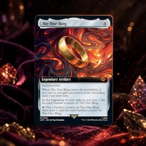 Peut inclure: Une carte à collectionner intitulée The One Ring, illustrée d'un anneau doré sur un fond de flammes orange et noires tourbillonnantes. Le texte de la carte comprend Legendary Artifact, Indestructible et des règles de jeu en blanc.