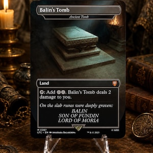 Puede incluir: Una carta coleccionable rectangular titulada Balin's Tomb, con una ilustración de una tumba de piedra sobre una plataforma escalonada. El texto de la carta incluye el nombre, el tipo Land y la inscripción: On the slab runes were deeply graven: BALIN SON OF FUNDIN LORD OF MORIA.