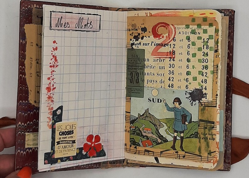 May include: Open journal with lined pages and vintage ephemera. The left page has the text "Mes Mots" and a floral design. The right page features a collage with the number "2" and a drawing of a child.