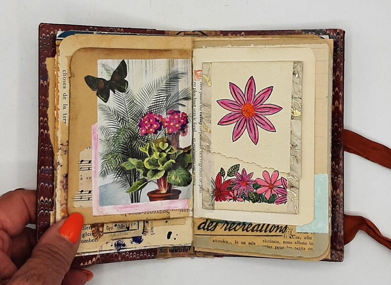 May include: Open journal with vintage pages featuring botanical illustrations and a butterfly. The left page displays a potted plant and a butterfly. The right page has a pink flower drawing and text.