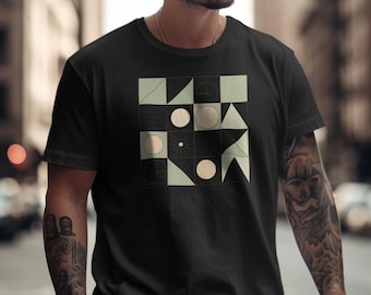 May include: Black t-shirt featuring a geometric design with squares, circles, triangles, and other shapes in light green and beige. The design is centered on the front of the shirt, creating a modern and artistic look. The shirt is short-sleeved.