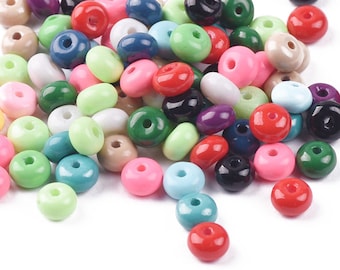 May include: A collection of small, round, glossy beads in a variety of solid colors including red, pink, green, blue, black, white, and beige. Each bead features a single centered hole, creating a uniform shape across the entire assortment.