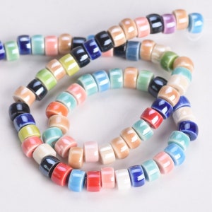 May include: A strand of colourful ceramic beads in various shades of blue, green, pink, red, and yellow. The beads are round and have a glossy finish.